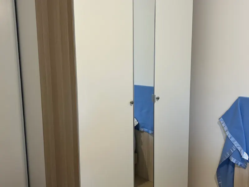 Dressing deux portes avec porte centrale miroir, finition blanche et bois clair installé à Caen